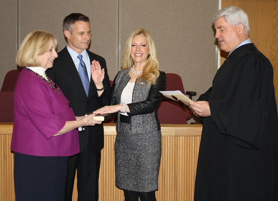 Monmouth County Clerk M. Claire French, whose retirement is effective later today, holds the bible as Christine Giordano Hanlon, standing next to her husband Robert Hanlon, is sworn-in as Acting County Clerk by Superior Court Judge Joseph W. Oxley on March 31 in Freehold, NJ. 